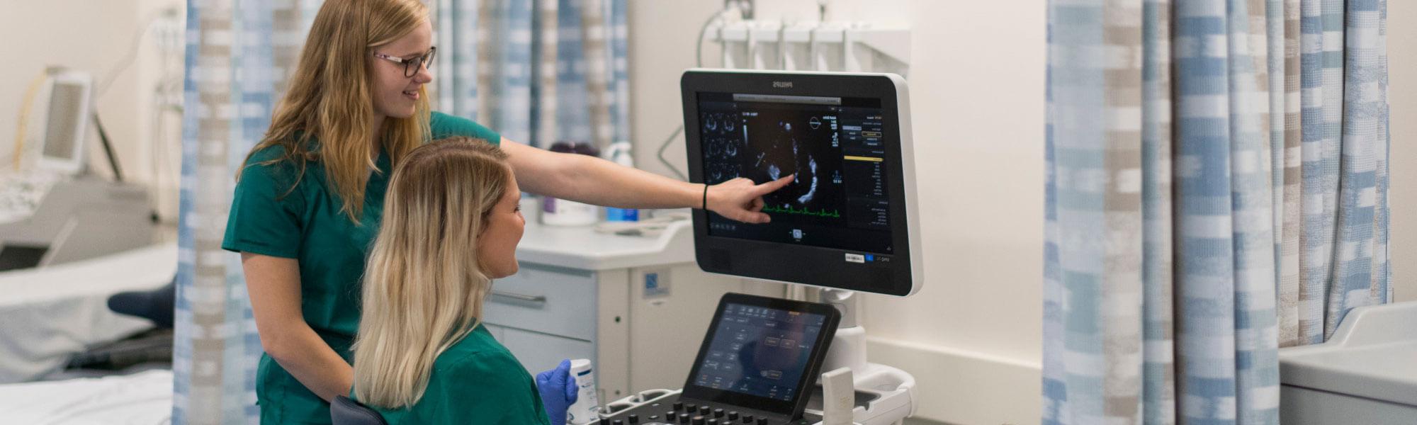 Photo of diagnostic sonography students in a lab at Grand Valley State University.